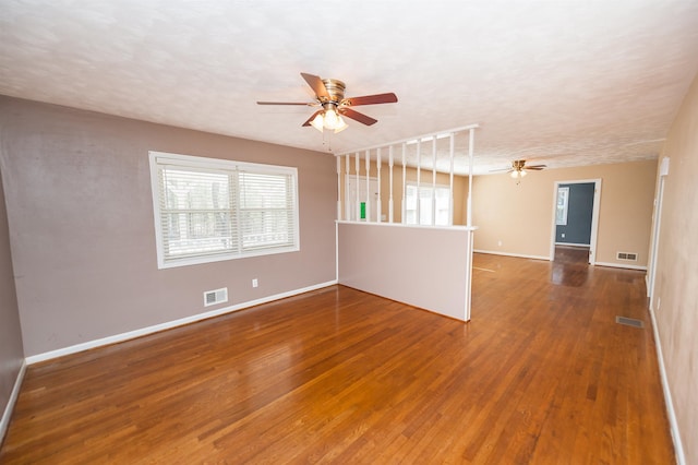 empty room with ceiling fan, visible vents, and wood finished floors