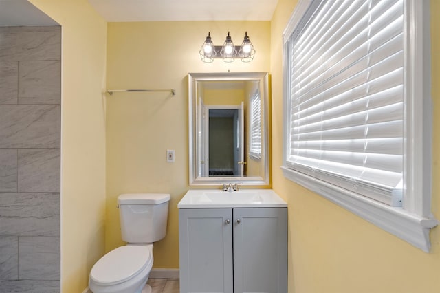 bathroom with baseboards, vanity, and toilet