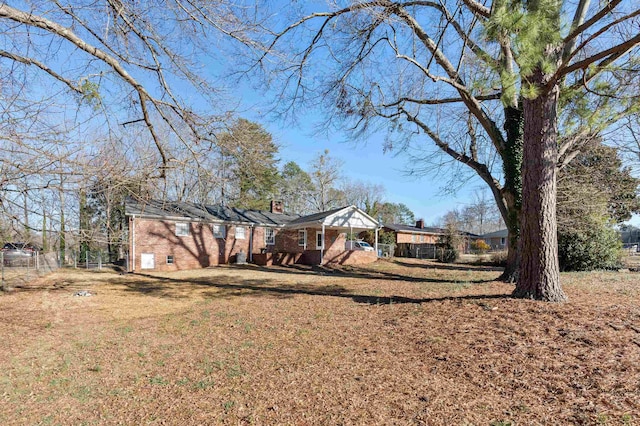 view of front of property featuring a front lawn, crawl space, a chimney, and brick siding