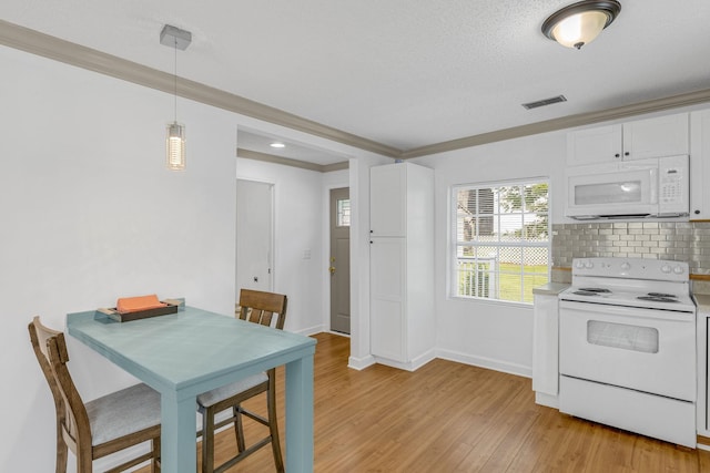 kitchen with white appliances, white cabinets, light wood-style flooring, hanging light fixtures, and light countertops