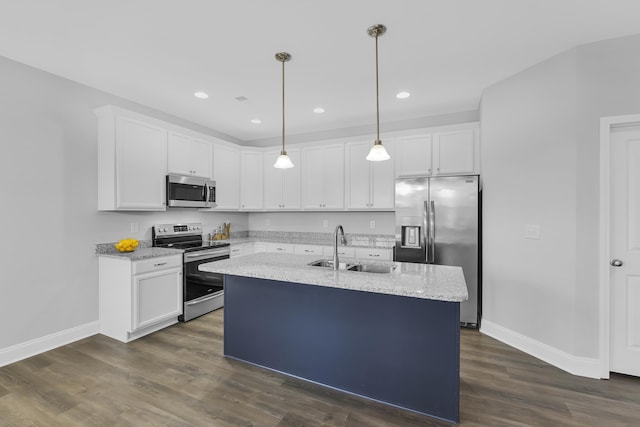 kitchen with white cabinets, appliances with stainless steel finishes, light stone counters, and a sink