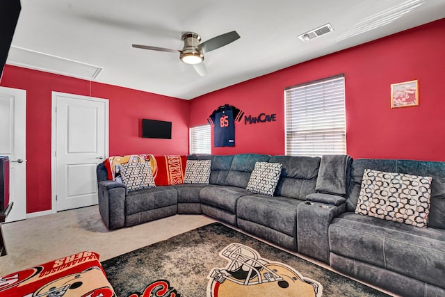 carpeted living room featuring attic access, visible vents, ceiling fan, and a wealth of natural light