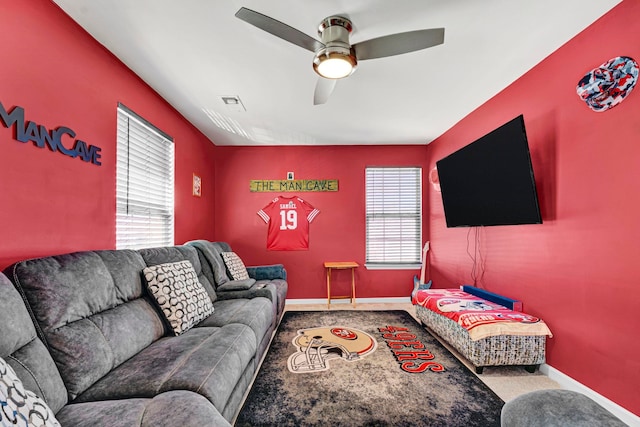 carpeted living room featuring ceiling fan, visible vents, and baseboards