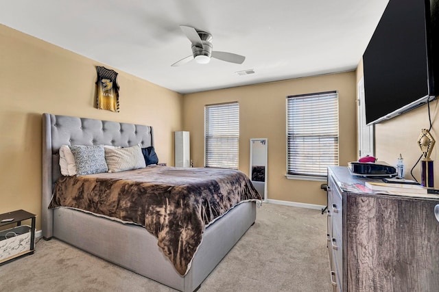 bedroom featuring light carpet, ceiling fan, visible vents, and baseboards