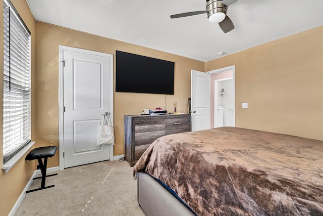 bedroom with light carpet, baseboards, a ceiling fan, and washer and dryer