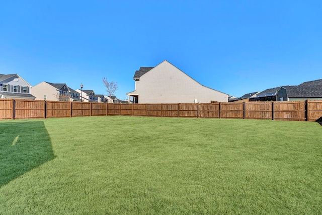 view of yard with a fenced backyard and a residential view