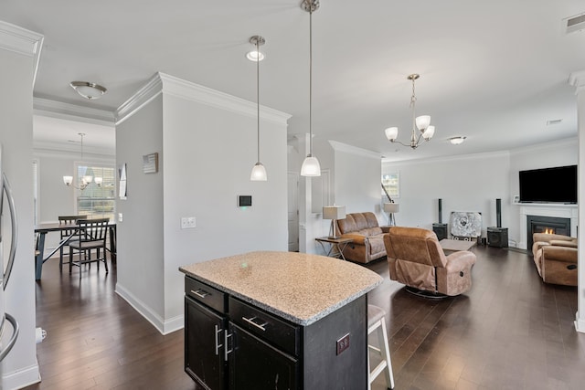 kitchen featuring hanging light fixtures, a kitchen island, a chandelier, and a breakfast bar area