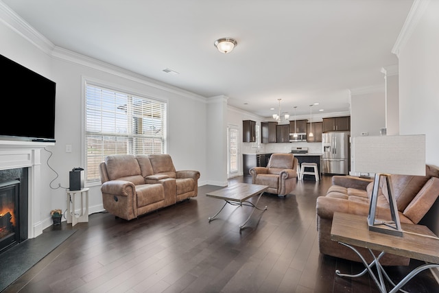 living area with ornamental molding, a high end fireplace, dark wood-type flooring, and visible vents