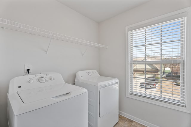 washroom with a wealth of natural light, laundry area, independent washer and dryer, and baseboards