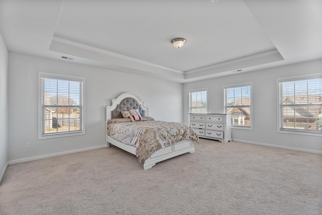 bedroom with light carpet, baseboards, and a tray ceiling