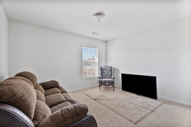 living area with baseboards and light colored carpet