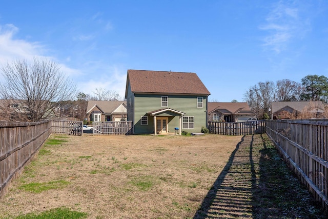 rear view of property with a residential view, a fenced backyard, and a lawn