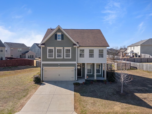 traditional home featuring concrete driveway, an attached garage, fence, and a residential view