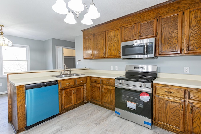 kitchen featuring light countertops, appliances with stainless steel finishes, and decorative light fixtures