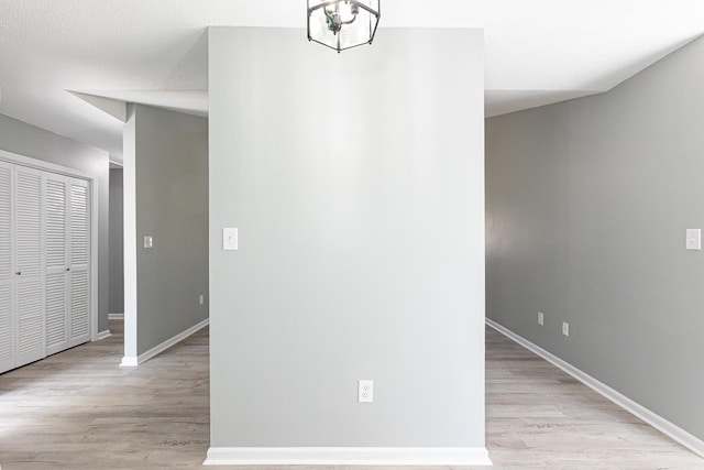 interior space with light wood-type flooring, baseboards, and a chandelier