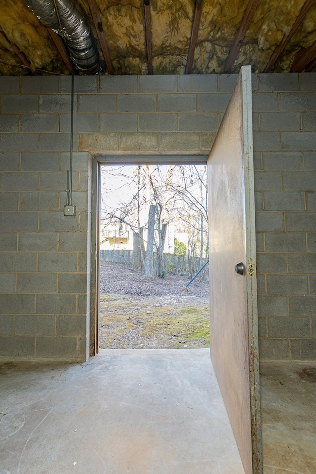 doorway to outside with unfinished concrete flooring