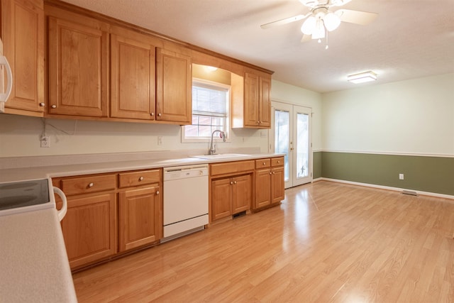 kitchen featuring white appliances, a ceiling fan, light wood-style flooring, light countertops, and a sink