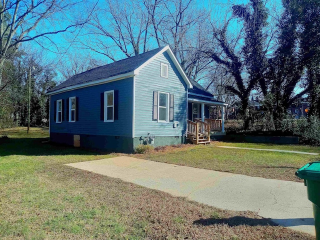 view of front facade with covered porch, a front lawn, crawl space, and a shingled roof