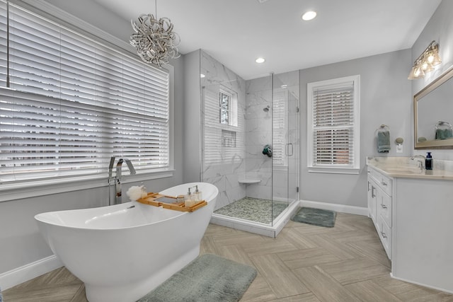 bathroom with a freestanding tub, recessed lighting, vanity, baseboards, and a stall shower