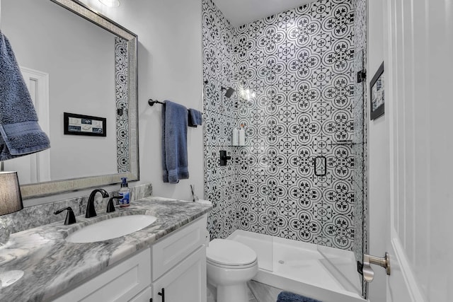 bathroom featuring tiled shower, vanity, and toilet