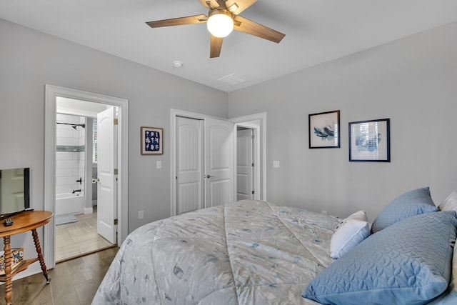 bedroom with ensuite bath, a closet, a ceiling fan, and wood finished floors