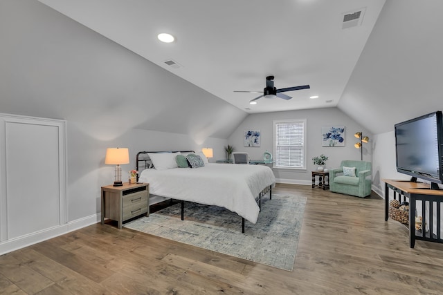 bedroom with lofted ceiling, visible vents, light wood-style flooring, and baseboards