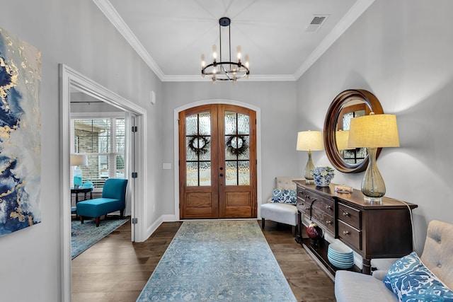 foyer with arched walkways, french doors, a notable chandelier, dark wood finished floors, and ornamental molding