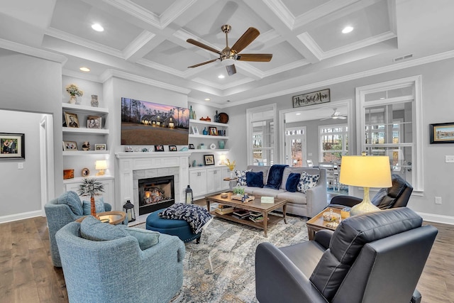 living room featuring a tile fireplace, coffered ceiling, visible vents, and wood finished floors