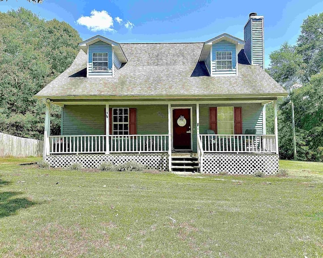 new england style home with covered porch, a front lawn, and a chimney