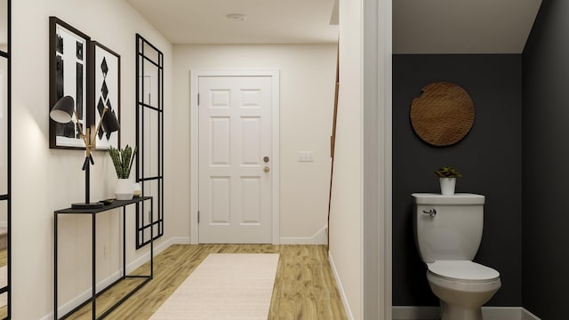 bathroom with wood finished floors, toilet, and baseboards