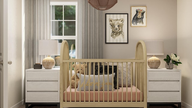 bedroom featuring a crib and baseboards