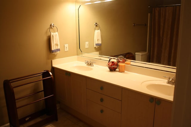 full bath featuring double vanity, tile patterned flooring, and a sink