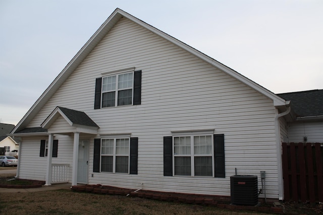 exterior space with roof with shingles, fence, and central AC unit