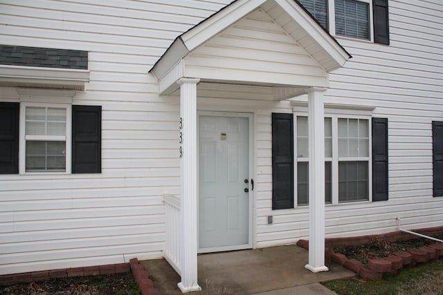 property entrance featuring a shingled roof