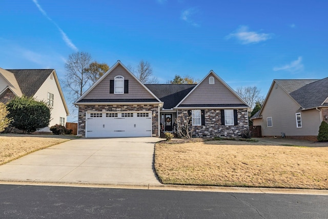 view of front of home with driveway, stone siding, and a garage