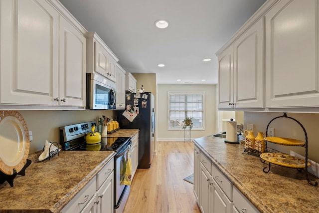 kitchen with light wood-style flooring, white cabinetry, stainless steel appliances, and recessed lighting