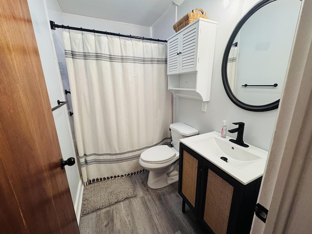 bathroom featuring toilet, curtained shower, wood finished floors, and vanity