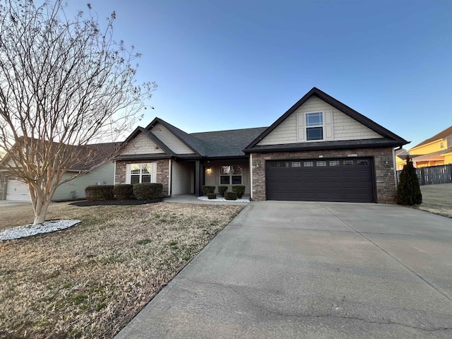 view of front of house featuring a garage, stone siding, and driveway