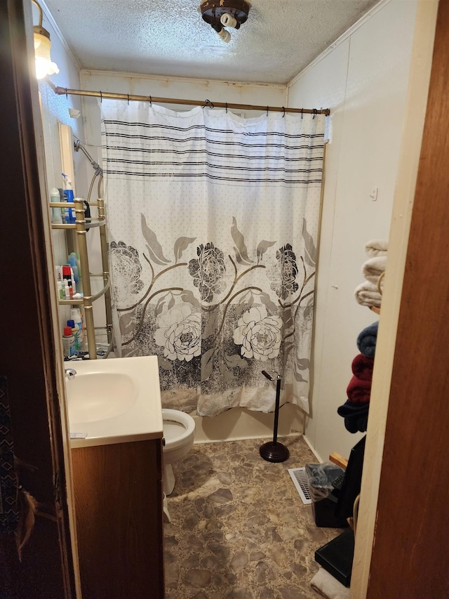 full bath with visible vents, toilet, ornamental molding, vanity, and a textured ceiling