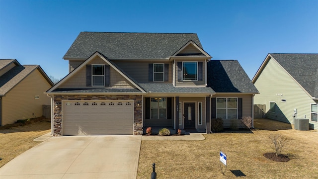 craftsman-style home with an attached garage, stone siding, concrete driveway, and roof with shingles