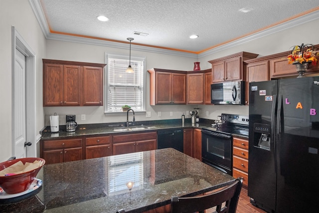 kitchen with decorative light fixtures, crown molding, a sink, dark stone counters, and black appliances