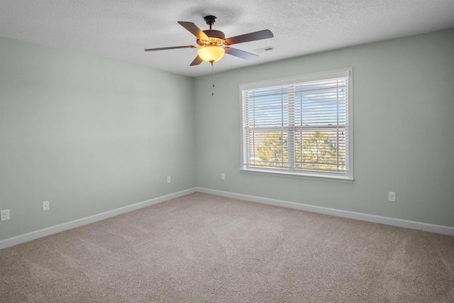 unfurnished room featuring a textured ceiling, carpet floors, a ceiling fan, visible vents, and baseboards