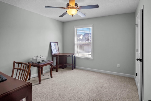 office with a ceiling fan, light colored carpet, a textured ceiling, and baseboards