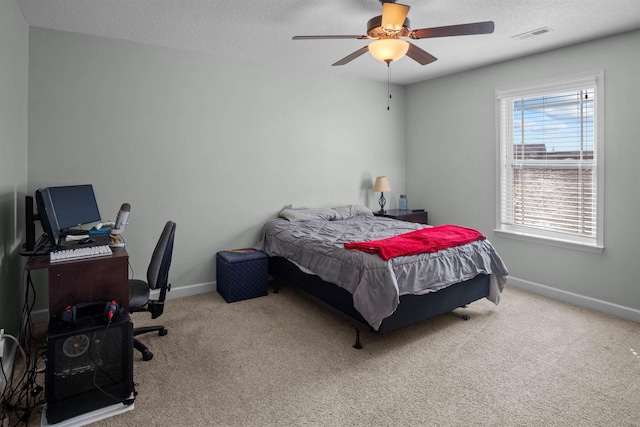 bedroom with light carpet, baseboards, and a textured ceiling