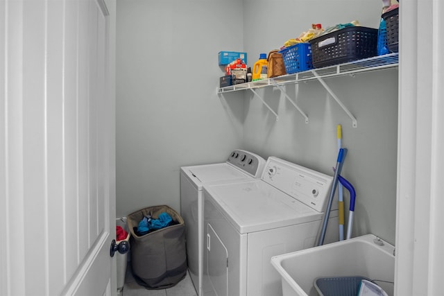 laundry area featuring laundry area, washing machine and dryer, and a sink