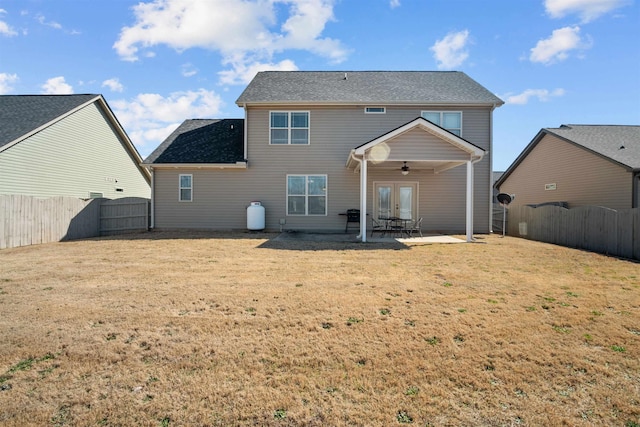 rear view of house with a lawn, a patio area, a fenced backyard, and a ceiling fan