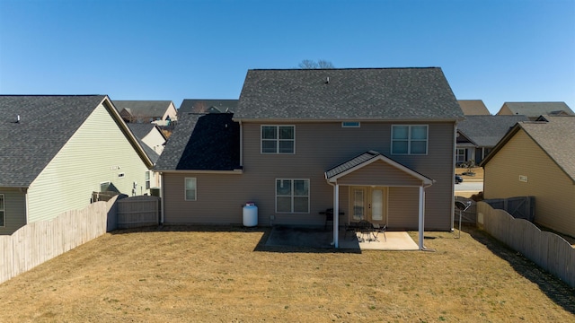 back of property with a yard, a fenced backyard, and a patio