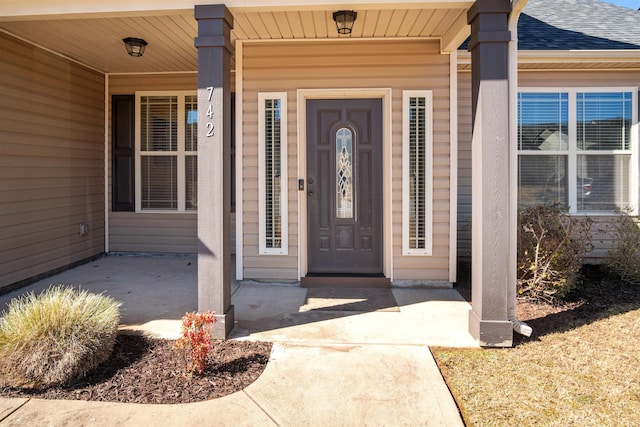 property entrance featuring roof with shingles