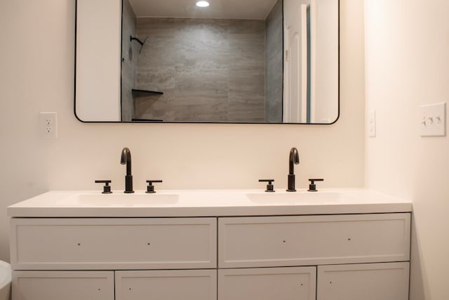 bathroom with recessed lighting, a sink, and double vanity