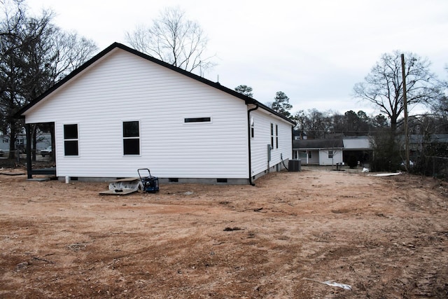 view of side of home with crawl space and central AC